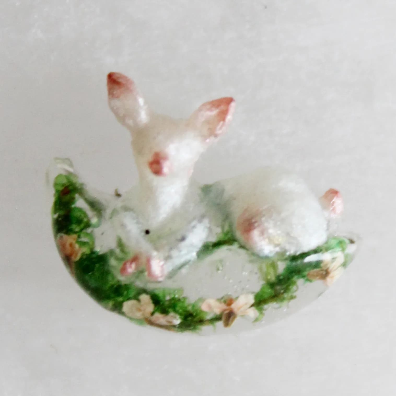 Dije de venado bebé en plata con flores preservadas